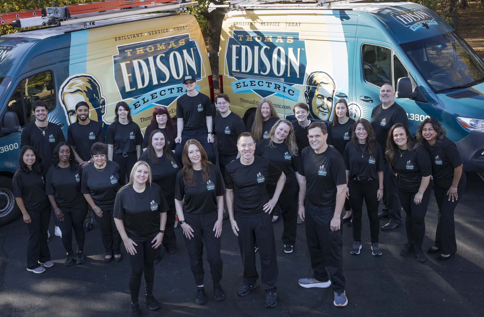 The Thomas Edison Electric team in front of the company vans